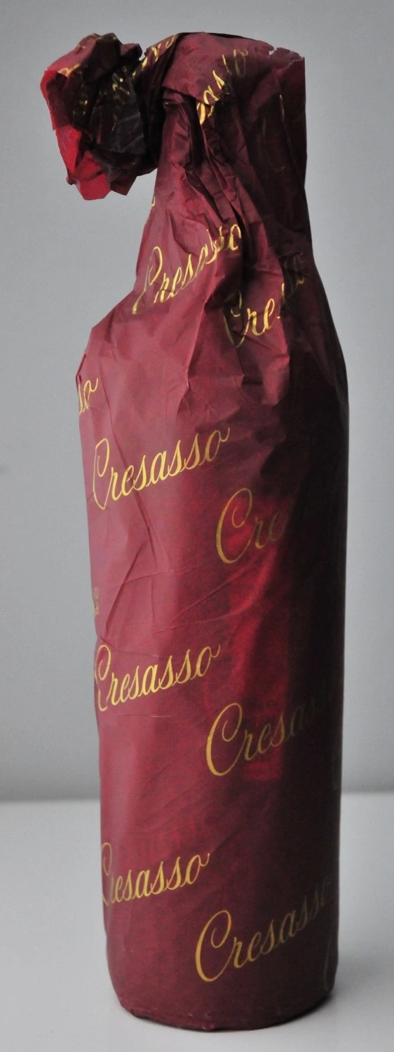 Wein Flasche in rotem Papier mit goldener Schrift, Cresasso