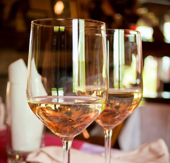 Zwei Weingläser mit Roséwein, die auf einem Tisch stehen, Nahaufnahme