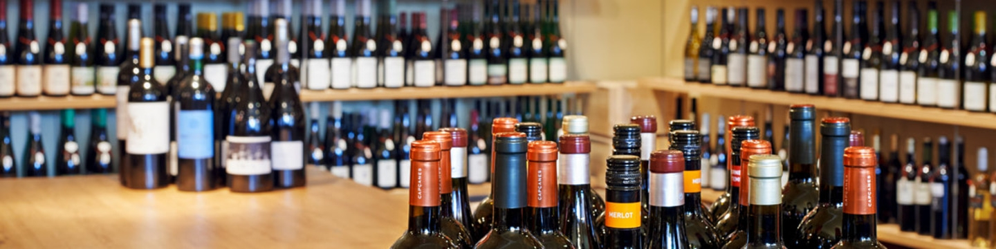 Weinregal mit vielen Weinflaschen, Nahaufnahme, Holzoberfläche, Weinhandlung