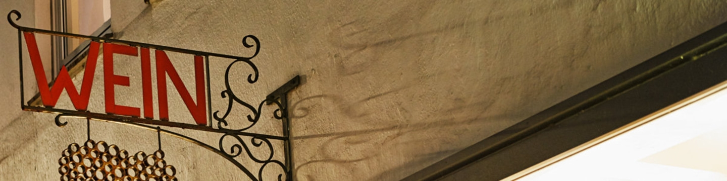 Wein-Schild mit roter Schrift an einer Hauswand, Detailaufnahme
