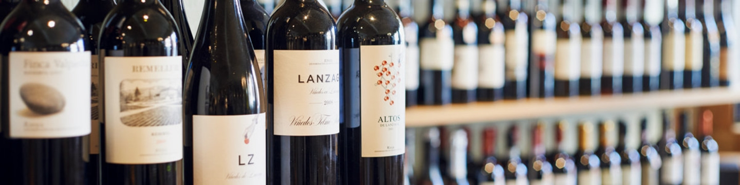 Weinregal mit verschiedenen Weinflaschen, Nahaufnahme, Fokus auf Etiketten