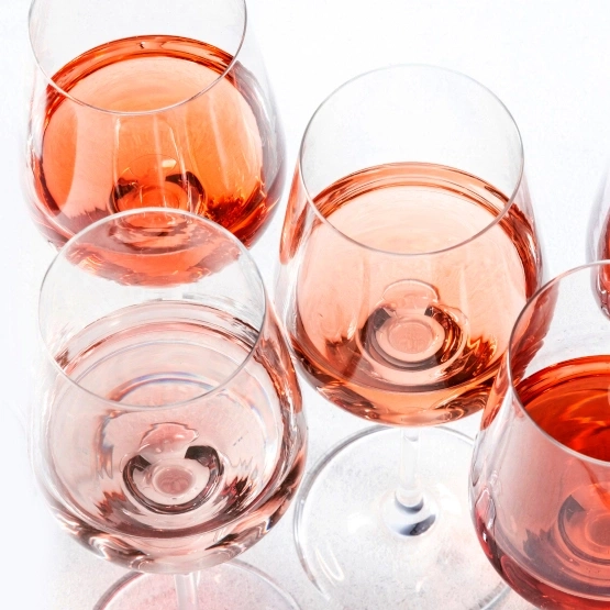Nahaufnahme von mehreren Weingläsern mit Roséwein auf weißem Hintergrund