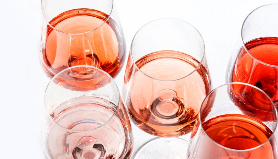 Nahaufnahme von Weingläsern mit Roséwein auf weißem Hintergrund