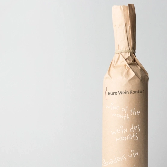 Weinflasche in Papier verpackt, mit Aufschrift 'Wine of the month'
