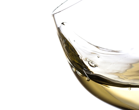 Nahaufnahme eines Weinglases mit Weißwein, isoliert auf Weiß