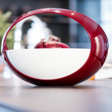 Rote Schüssel mit Zwiebeln auf einer Küchenoberfläche. Modernes Design.